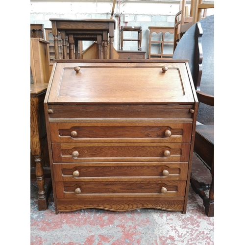 47 - An oak bureau with four drawers and fall front - approx. 91cm high x 80cm wide x 43cm deep