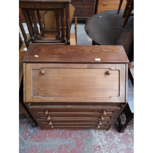 47 - An oak bureau with four drawers and fall front - approx. 91cm high x 80cm wide x 43cm deep