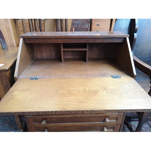 47 - An oak bureau with four drawers and fall front - approx. 91cm high x 80cm wide x 43cm deep