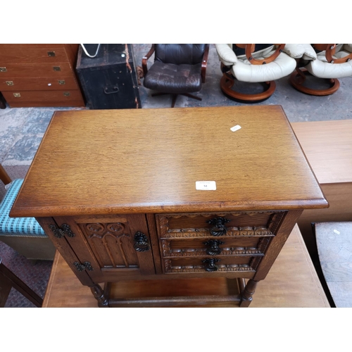 51 - A carved oak joint side cabinet with three drawers and single cupboard door - approx. 68cm high x 59... 