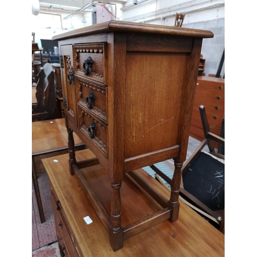 51 - A carved oak joint side cabinet with three drawers and single cupboard door - approx. 68cm high x 59... 