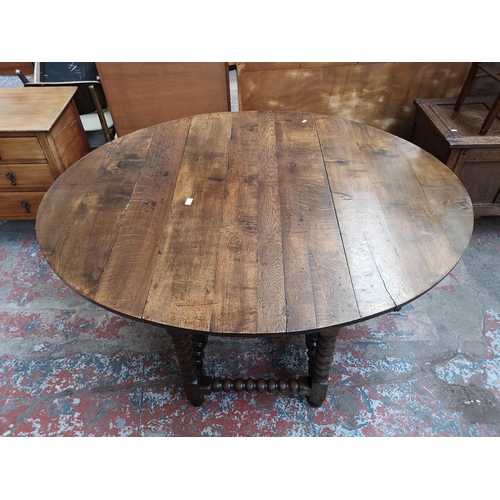 53 - A 17th century style solid oak bobbin turned drop leaf gate leg dining table - approx. 74cm high x 1... 