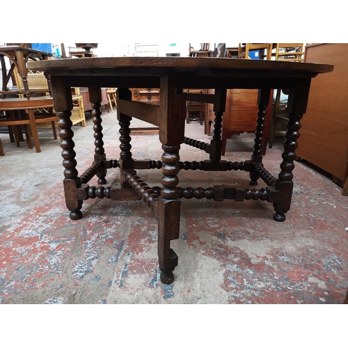 53 - A 17th century style solid oak bobbin turned drop leaf gate leg dining table - approx. 74cm high x 1... 