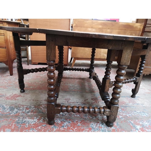 53 - A 17th century style solid oak bobbin turned drop leaf gate leg dining table - approx. 74cm high x 1... 