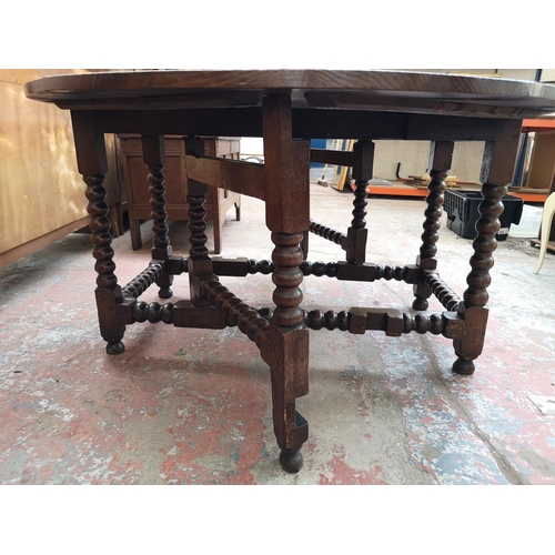 53 - A 17th century style solid oak bobbin turned drop leaf gate leg dining table - approx. 74cm high x 1... 