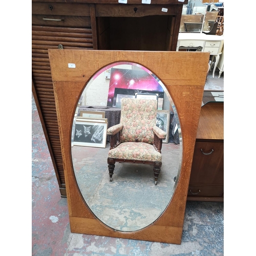 56 - An early 20th century oak framed bevelled edge wall mirror - approx. 132cm high x 82cm wide