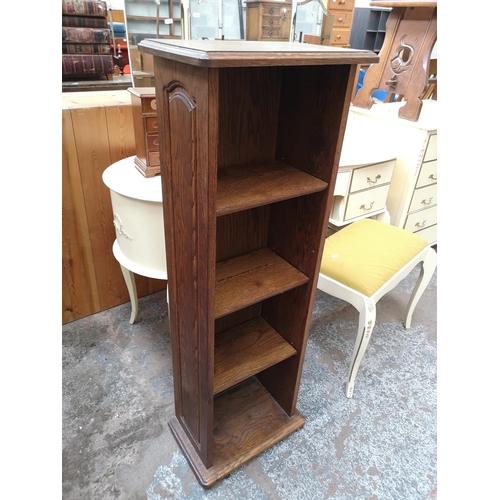 57 - An oak four tier free standing open bookcase - approx. 116cm high x 40cm wide x 25cm deep