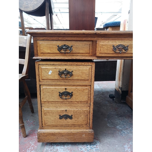 69 - An early 20th century oak pedestal desk with eight drawers and red leather insert - approx. 81cm hig... 