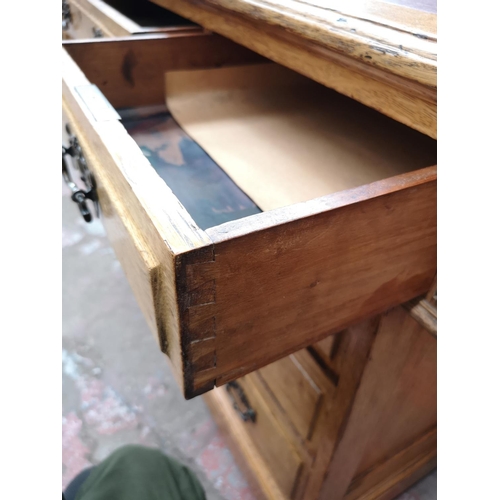 69 - An early 20th century oak pedestal desk with eight drawers and red leather insert - approx. 81cm hig... 