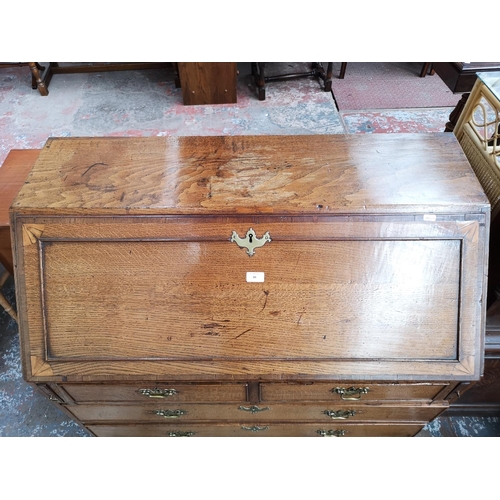 89 - A George III inlaid oak and mahogany crossbanded bureau with fitted interior, two short drawers, thr... 