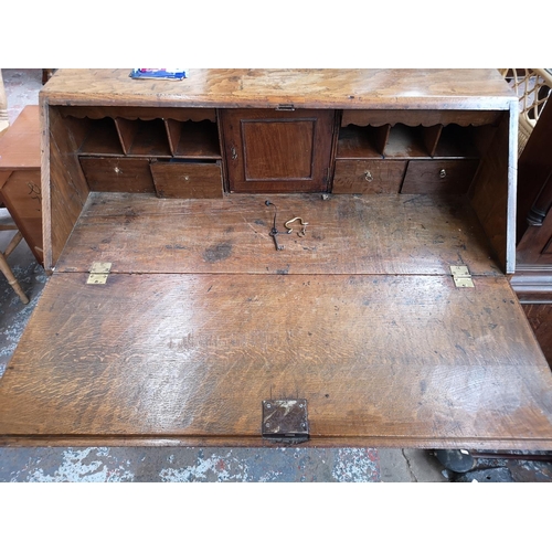 89 - A George III inlaid oak and mahogany crossbanded bureau with fitted interior, two short drawers, thr... 