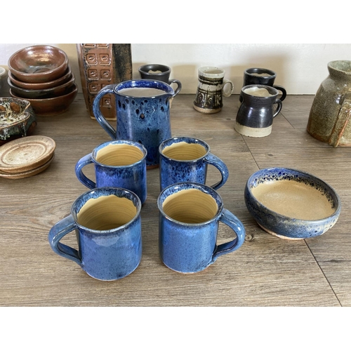 373 - A large collection of studio pottery to include Ayrton Looe blue drip glazed jug, mugs and bowl etc.