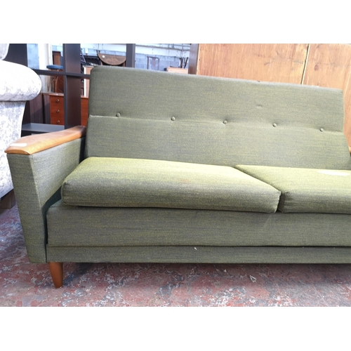 131 - A mid 20th century Greaves & Thomas green upholstered and teak two seater sofa bed