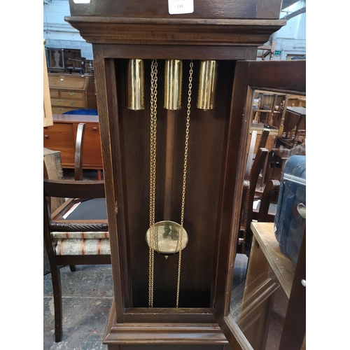 134 - A late 20th century oak cased grandmother clock with weights and pendulum - approx. 188cm high x 36c... 