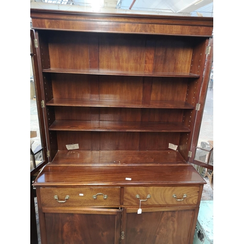 144 - A Georgian style mahogany bookcase with two upper astral glazed doors, two drawers and two lower cup... 