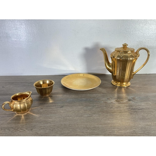 394 - A collection of Wade gold coloured china to include six cups, six saucers, coffee pot etc.