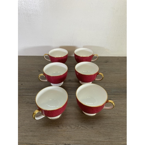 415 - A collection of Wedgwood pattern W4206 powder ruby red bone china to include seven tea cups, six sau... 