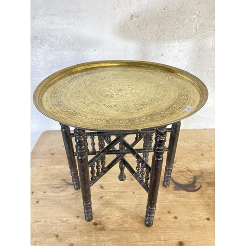 444 - Three items, two brass circular trays - approx. 58cm in diameter and one wooden folding travel table