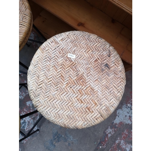 34 - Three mid 20th century wicker and black metal kitchen bar stools - approx. 74cm high x 33cm diameter