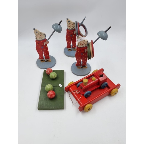 477 - A collection of vintage wooden toys to include three hoopla clowns, pull along train with mechanical... 