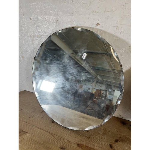 181 - Two mid 20th century frameless bevelled edge circular wall hanging mirrors