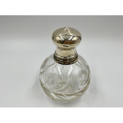 1258 - A cut glass hallmarked silver topped scent bottle - approx. 12.5cm high