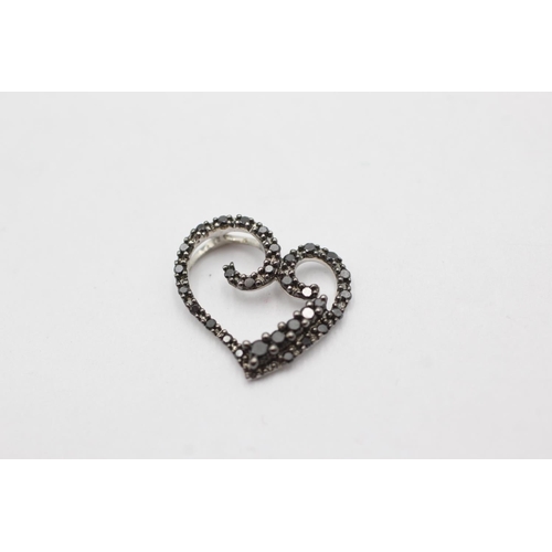 1071 - A 9ct white gold black diamond set heart pendant - approx. gross weight 1.2 grams