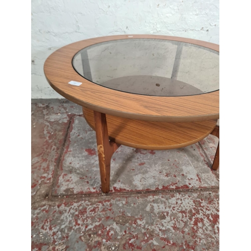 107 - A mid 20th century teak effect and smoked glass circular two tier coffee table - approx. 45cm high x... 