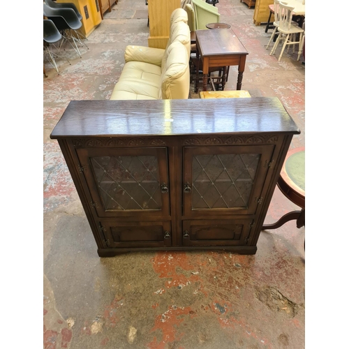 128 - An oak bookcase with two leaded glass doors and two lower cupboard doors - approx. 98cm high x 106cm... 