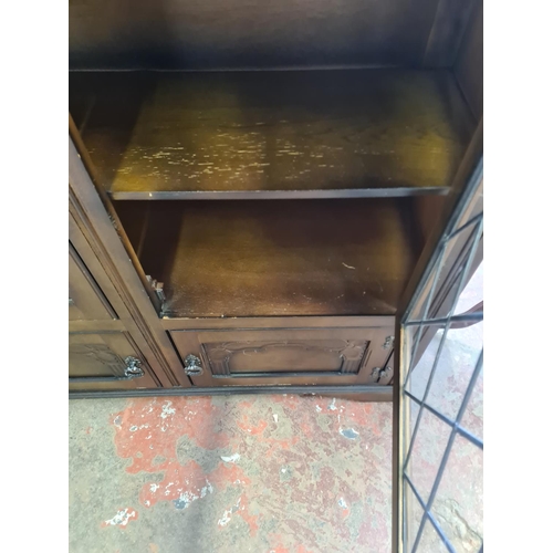 128 - An oak bookcase with two leaded glass doors and two lower cupboard doors - approx. 98cm high x 106cm... 