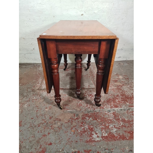 14 - A Victorian mahogany drop leaf gate leg dining table with original brass castors - approx. 74cm high... 