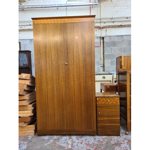 141 - A mid 20th century Uniflex walnut two piece bedroom suite comprising double wardrobe and bedside cab... 