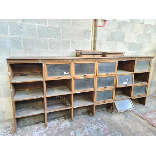 147 - An early 20th century oak twenty four section barristers bookcase - approx. 131cm high x 310cm wide ... 