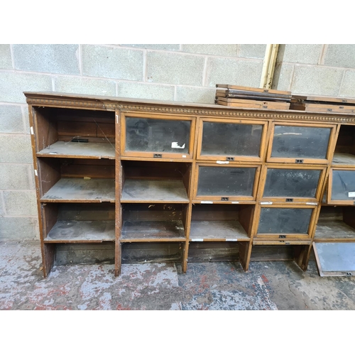 147 - An early 20th century oak twenty four section barristers bookcase - approx. 131cm high x 310cm wide ... 