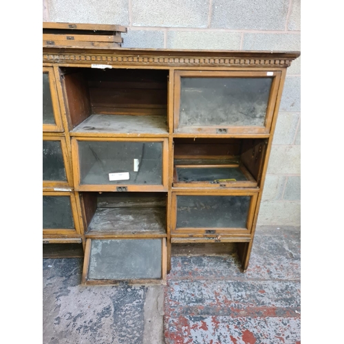 147 - An early 20th century oak twenty four section barristers bookcase - approx. 131cm high x 310cm wide ... 