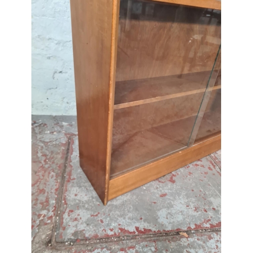 17 - A Herbert Gibbs teak four tier bookcase with four glass sliding doors - approx. 112cm high x 91cm wi... 