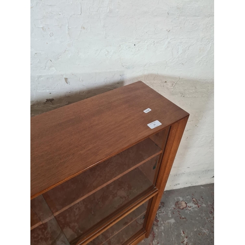 17 - A Herbert Gibbs teak four tier bookcase with four glass sliding doors - approx. 112cm high x 91cm wi... 