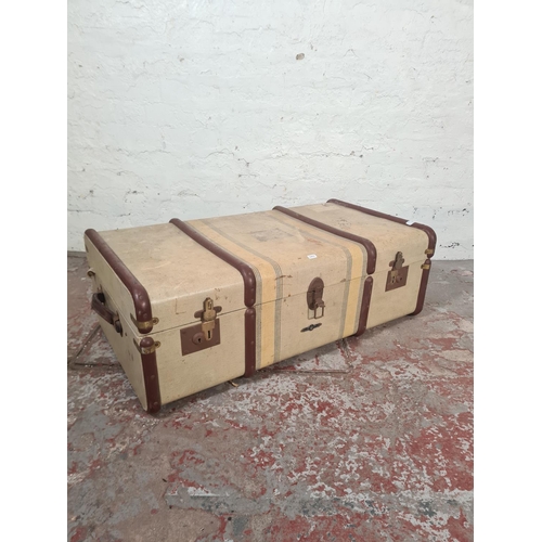 25 - A mid 20th century canvas and metal banded travel trunk - approx. 31cm high x 90cm wide x 50cm deep