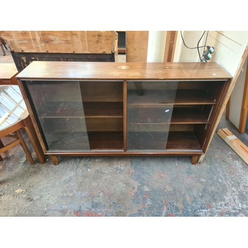 35 - A mid 20th century Minty mahogany bookcase with four glass sliding doors - approx. 86cm high x 154cm... 