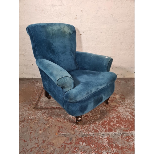 46 - A Victorian blue fabric upholstered armchair with mahogany supports and castors - approx. 96cm high ... 