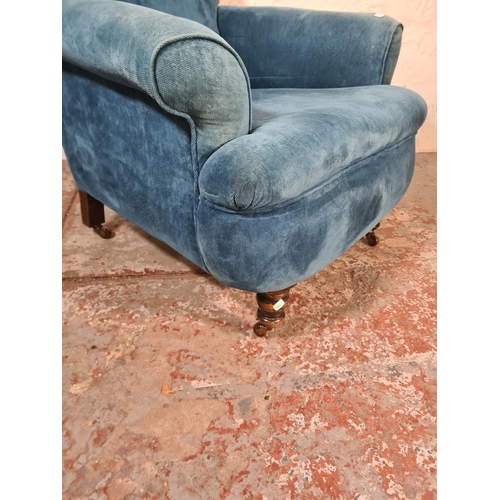 46 - A Victorian blue fabric upholstered armchair with mahogany supports and castors - approx. 96cm high ... 