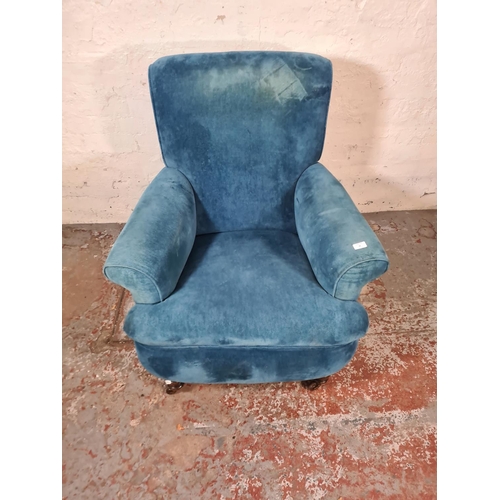 46 - A Victorian blue fabric upholstered armchair with mahogany supports and castors - approx. 96cm high ... 