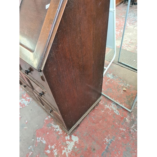 79 - A mid 20th century oak bureau with carved fall front and three drawers