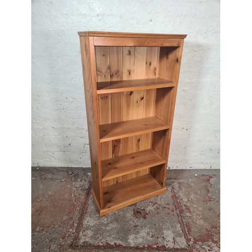 8 - A modern solid pine four tier freestanding bookcase - approx. 122cm high x 59cm wide x 23cm deep