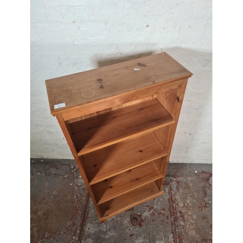 8 - A modern solid pine four tier freestanding bookcase - approx. 122cm high x 59cm wide x 23cm deep