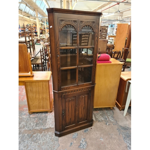 91 - An oak linenfold freestanding corner cabinet - approx. 176cm high x 71cm wide x 40cm deep