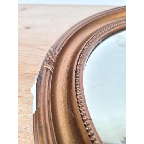 171 - An early 20th century gilt framed oval bevelled edge wall mirror - approx. 44cm high x 38cm wide