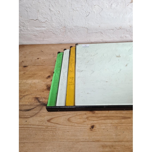 185 - An Art Deco style tinted glass and bevelled edge wall mirror - approx. 85cm wide x 41cm high