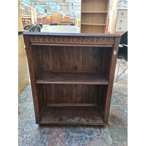 148B - A carved oak two tier free standing open bookcase - approx. 82cm high x 67cm wide x 28cm deep