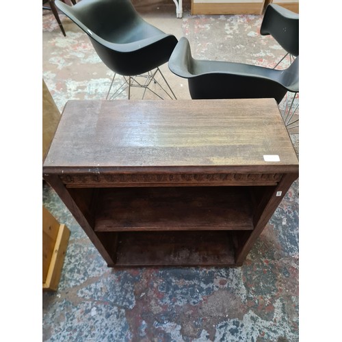 148B - A carved oak two tier free standing open bookcase - approx. 82cm high x 67cm wide x 28cm deep